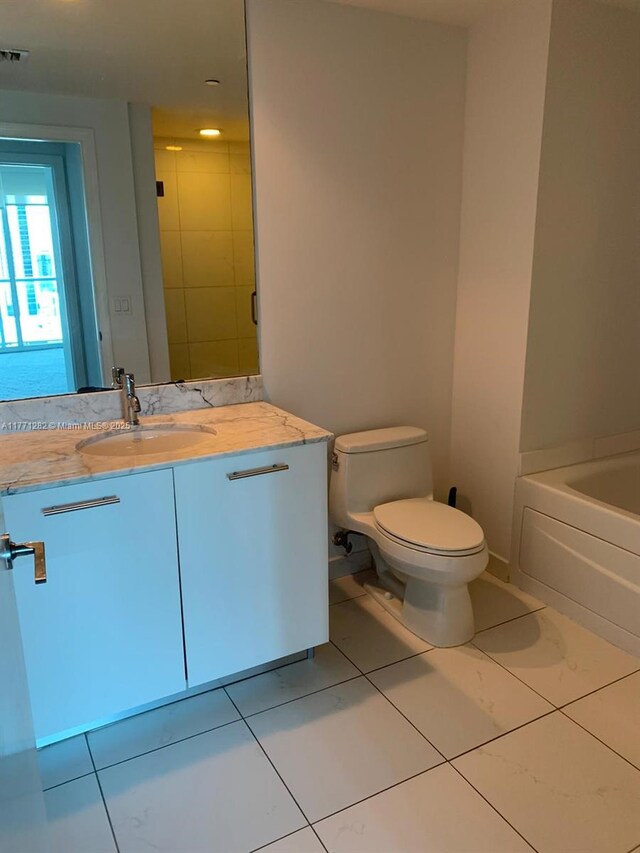 55 SE 6th St Unit 2404, Miami, FL 33131 - bathroom featuring toilet, vanity, a tub to relax in, and visible vents