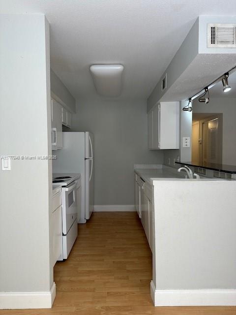 2607 NW 33rd St Unit 2111, Oakland Park, FL 33309 - kitchen featuring white cabinetry, white range with electric stovetop, baseboards, visible vents, and light wood-style flooring