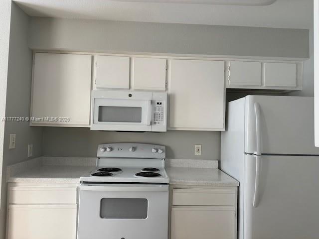 2607 NW 33rd St Unit 2111, Oakland Park, FL 33309 - kitchen with light countertops, white cabinets, and white appliances