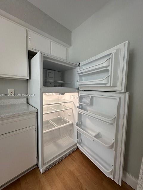 2607 NW 33rd St Unit 2111, Oakland Park, FL 33309 - details featuring fridge, light countertops, wood finished floors, and white cabinets