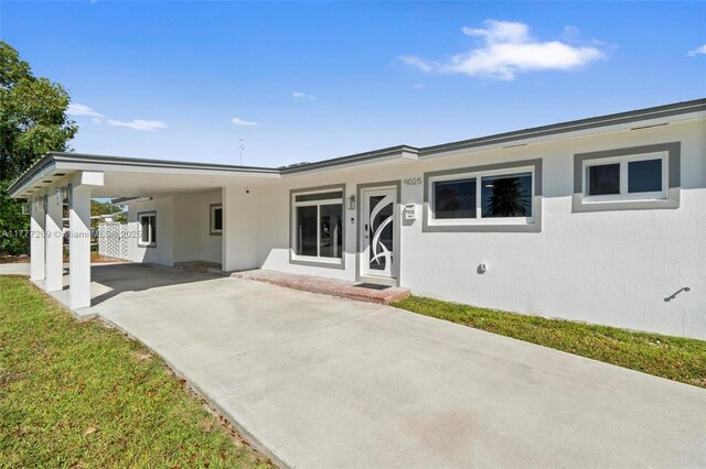9025 SW 56th St, Miami, FL 33165 - back of property with concrete driveway, stucco siding, and an attached carport