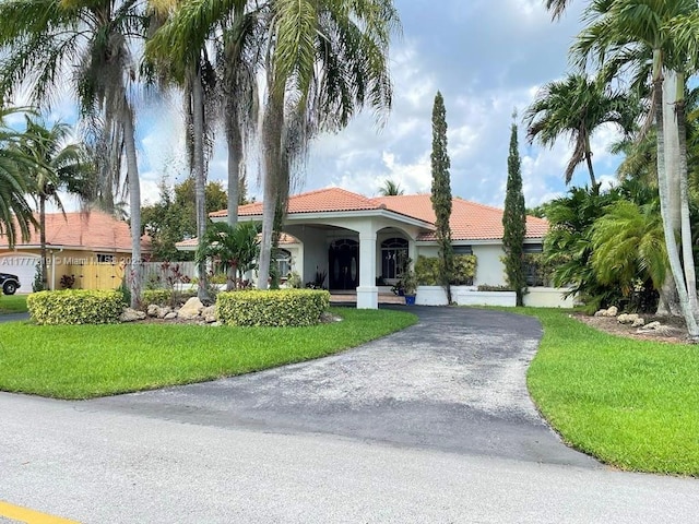 12421 SW 76th St, Miami, FL 33183 - mediterranean / spanish home featuring aphalt driveway, stucco siding, a front lawn, and a tile roof