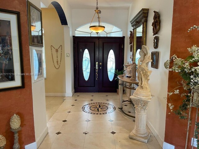 12421 SW 76th St, Miami, FL 33183 - foyer entrance featuring light tile patterned floors, baseboards, and arched walkways