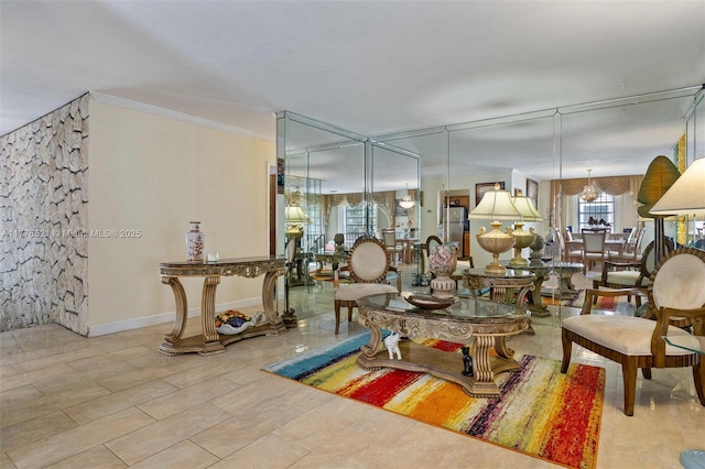 living area with baseboards, ornamental molding, and a chandelier