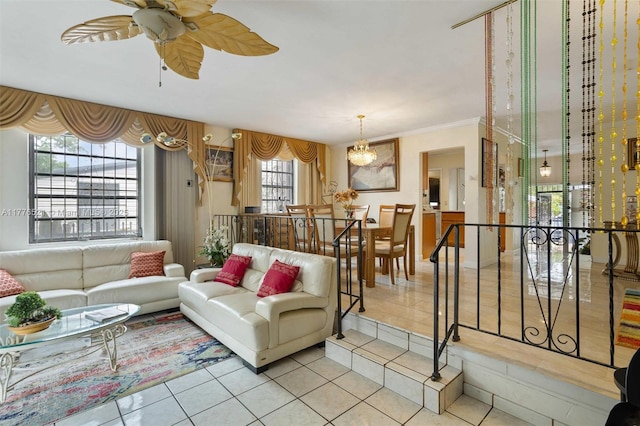 tiled living area featuring ornamental molding and ceiling fan with notable chandelier