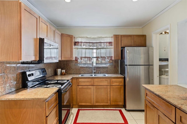 kitchen featuring light countertops, a sink, appliances with stainless steel finishes, light tile patterned floors, and decorative backsplash