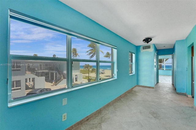 interior space featuring baseboards, visible vents, and a healthy amount of sunlight
