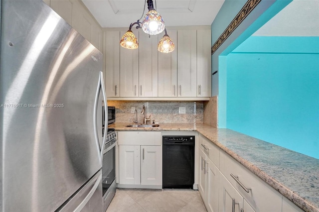 kitchen featuring a sink, decorative backsplash, light tile patterned floors, white cabinets, and appliances with stainless steel finishes
