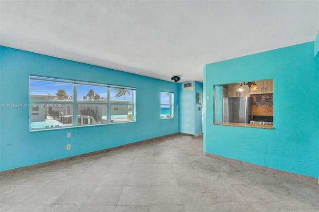 unfurnished room featuring baseboards and visible vents