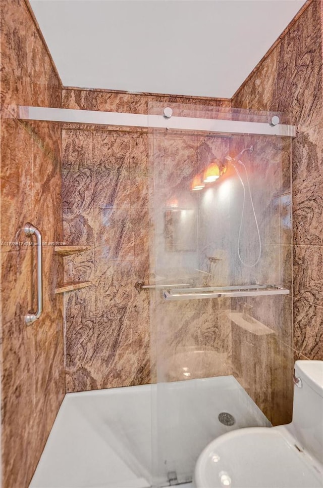 bathroom featuring a shower stall and toilet