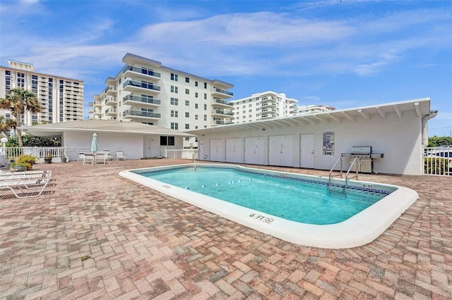 community pool with a patio area and fence