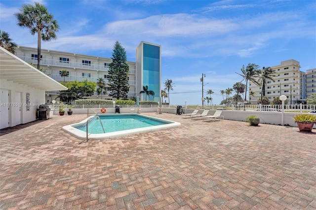 community pool featuring a patio and fence