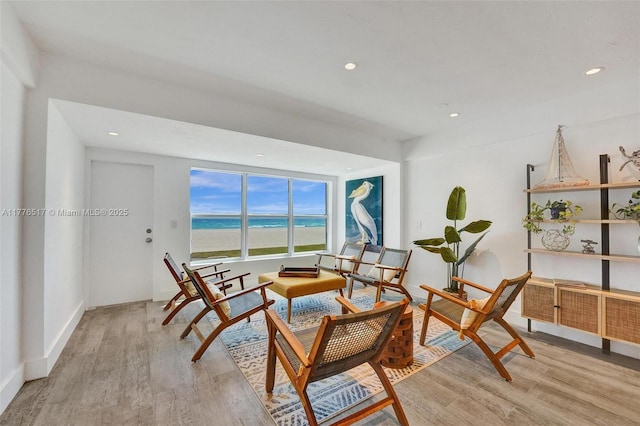 living area with light wood-style flooring, baseboards, recessed lighting, and a water view