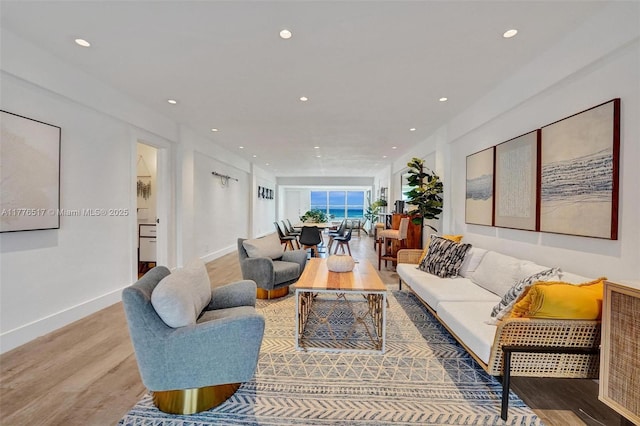 living area featuring recessed lighting, light wood-style floors, and baseboards