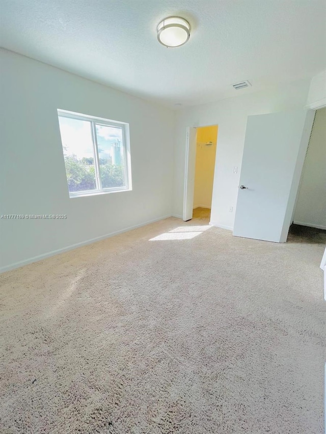 empty room with baseboards and visible vents