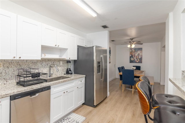 kitchen featuring white cabinets, light wood-style floors, visible vents, appliances with stainless steel finishes, and a sink