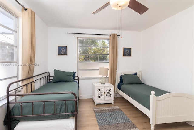 bedroom with baseboards, a ceiling fan, and wood finished floors