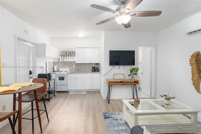 kitchen with light wood-style floors, white cabinets, white range with electric stovetop, light countertops, and a sink