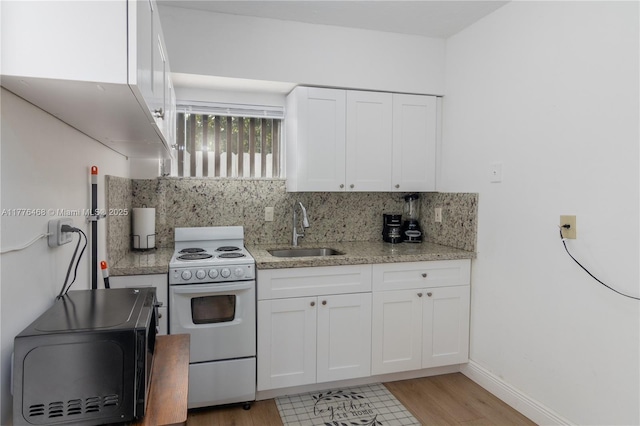 kitchen with black microwave, electric range, a sink, and decorative backsplash