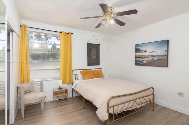 bedroom featuring baseboards, a ceiling fan, and wood finished floors