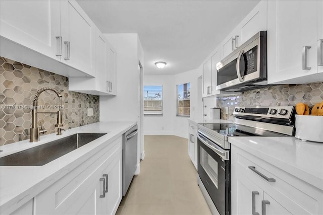 650 SW 124th Ter Unit 105P, Pembroke Pines, FL 33027 - kitchen featuring appliances with stainless steel finishes, a sink, backsplash, white cabinets, and light countertops
