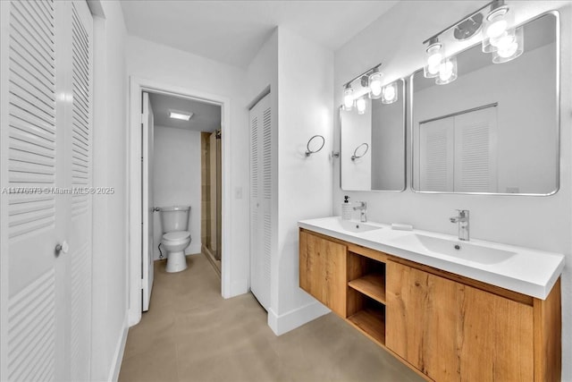 650 SW 124th Ter Unit 105P, Pembroke Pines, FL 33027 - bathroom featuring a closet, toilet, double vanity, and baseboards