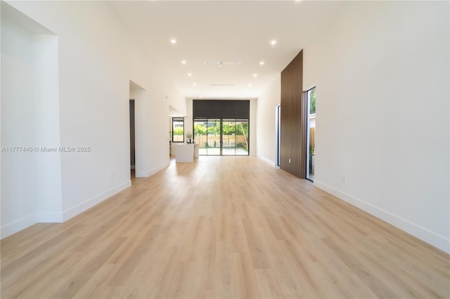 empty room with baseboards, light wood finished floors, and recessed lighting