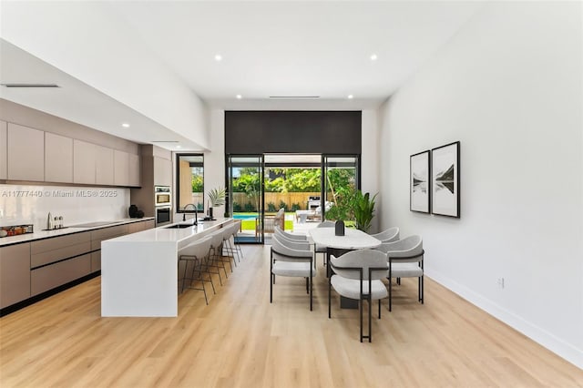 dining space with baseboards, light wood-style floors, and recessed lighting