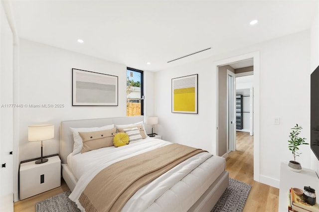 bedroom featuring baseboards, light wood-style flooring, and recessed lighting