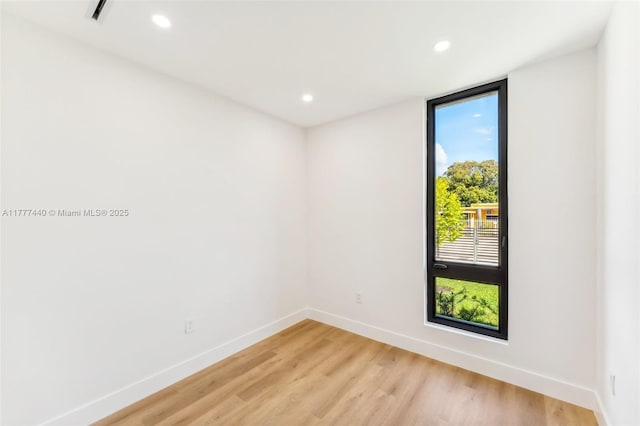 unfurnished room with light wood-style flooring, baseboards, and recessed lighting