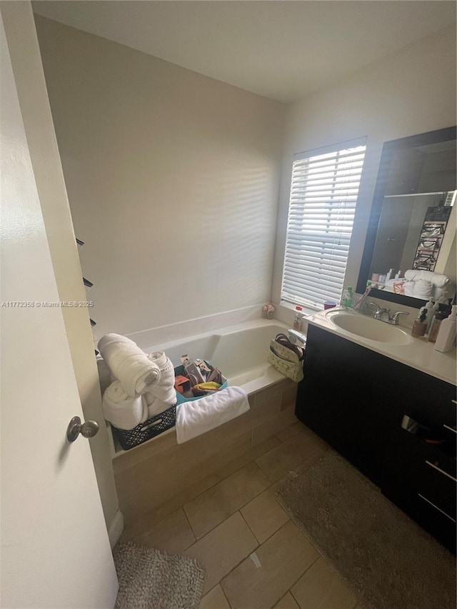 bathroom featuring tile patterned floors, vanity, and a bath