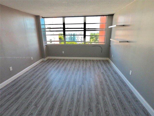 1301 NE Miami Gardens Dr Unit 1115W, Miami, FL 33179 - spare room featuring wood finished floors and a textured ceiling