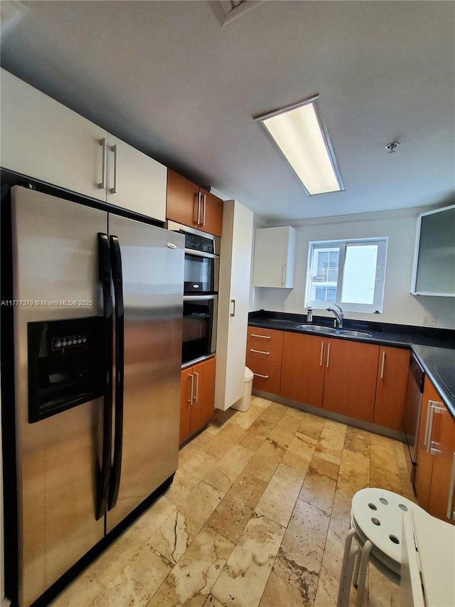170 SE 14th St Unit 2705, Miami, FL 33131 - kitchen with appliances with stainless steel finishes, a sink, dark countertops, brown cabinets, and stone tile floors