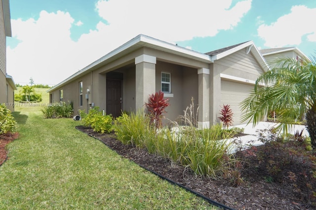 view of home's exterior featuring a lawn, stucco siding, and an attached garage