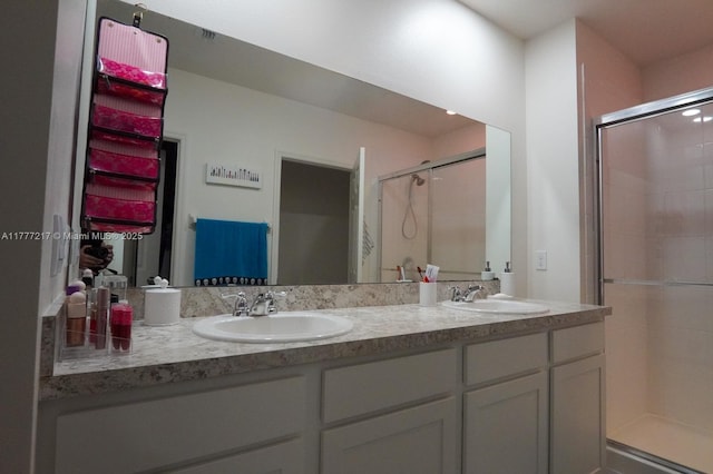full bathroom with double vanity, a sink, and a stall shower