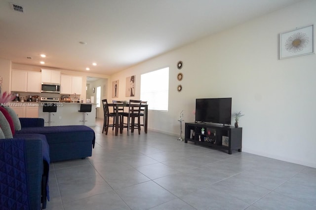 living area featuring baseboards, visible vents, recessed lighting, and light tile patterned floors