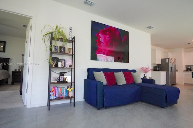 living area featuring visible vents and light tile patterned floors