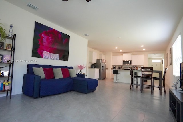 living room featuring a ceiling fan, recessed lighting, light tile patterned floors, and visible vents
