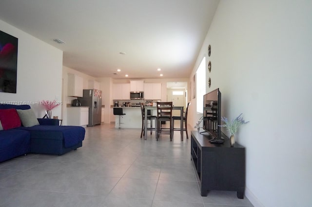 living room with light tile patterned flooring, baseboards, visible vents, and recessed lighting