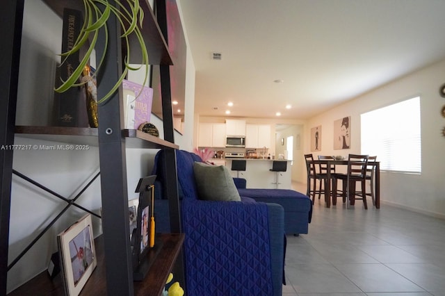 living area with baseboards, visible vents, recessed lighting, and light tile patterned floors