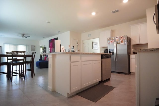 kitchen with visible vents, ceiling fan, a kitchen island, appliances with stainless steel finishes, and white cabinetry