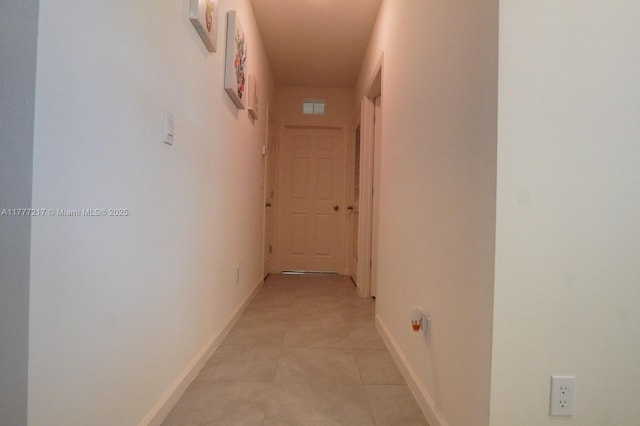 hall featuring baseboards and visible vents