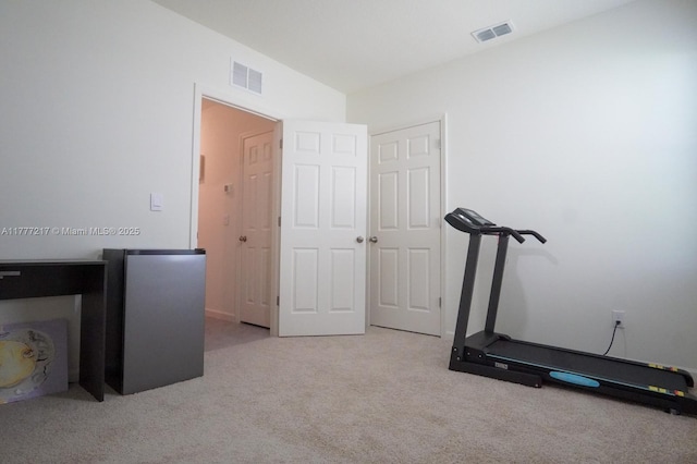 workout room featuring visible vents, vaulted ceiling, and carpet