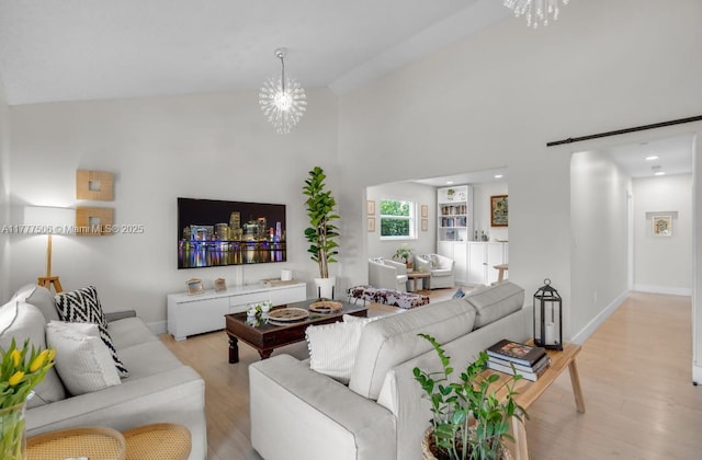 living area featuring light wood-type flooring, high vaulted ceiling, an inviting chandelier, and baseboards