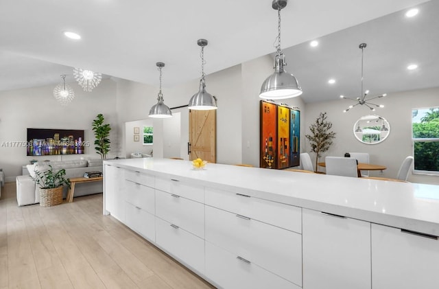 kitchen with light wood finished floors, modern cabinets, an inviting chandelier, and white cabinetry