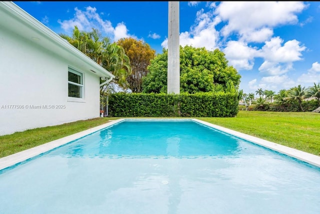 view of swimming pool featuring a fenced in pool and a lawn