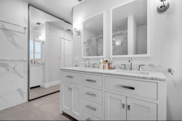 full bathroom with a sink, a marble finish shower, and double vanity