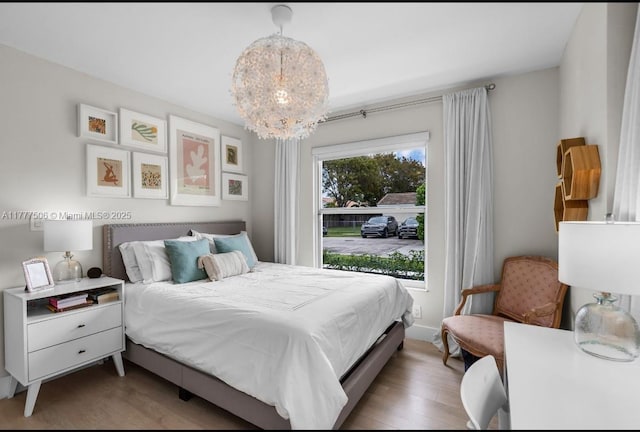 bedroom with a chandelier and light wood finished floors
