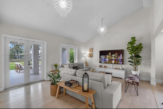 living room with french doors, high vaulted ceiling, a chandelier, and light wood-style floors