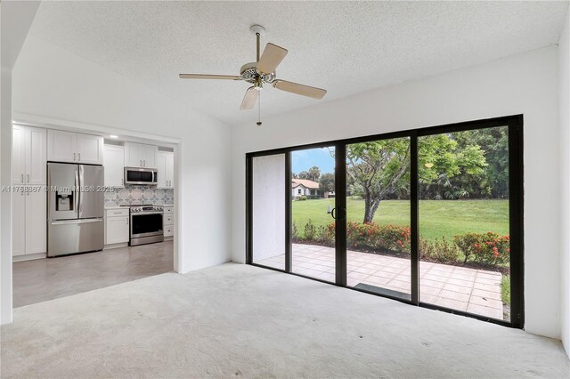 3774 SW Pheasant Run, Palm City, FL 34990 - unfurnished living room with light carpet, a ceiling fan, lofted ceiling, and a textured ceiling